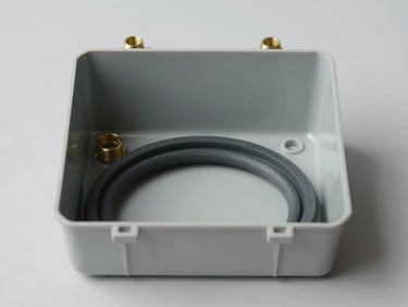 Straight-on technical studio shot of an open IP65 thermoplastic junction box, showing the thick gray rubber sealing gasket, brass screw threads, and clean interior mounting plate, neutral light gray background.
