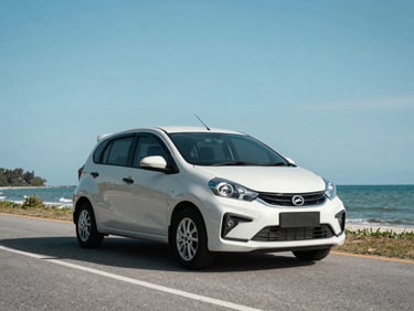 Medium shot of a Perodua Myvi on a scenic coastal road in Sabah, clear blue sky.
