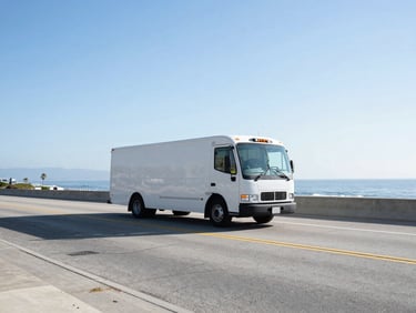 Wide environmental shot of a clean transport vehicle on a coastal highway in Southern California, bright morning daylight, cool blue tones