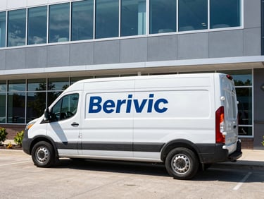 Branded service vehicle parked outside a modern office building in Wisconsin, bright natural daylight, medium environmental shot, cool blue and slate tones.