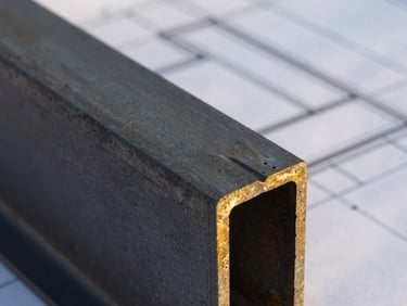 Close-up of premium structural steel and concrete joints, architectural blueprint lines visible in background