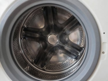 Close-up of a clean metallic washing machine drum, focus on the texture