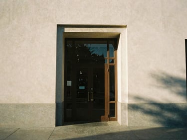 Warm sunlight illuminating the architectural entrance of a historic community center in Los Angeles, soft shadows, 35mm lens
