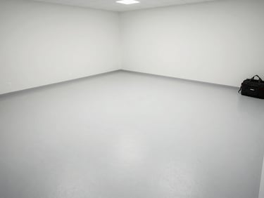 Wide environmental shot of a treated empty room, clean surfaces under clear daylight, a technician's equipment bag visible in the corner as evidence of completed work, overhead documentation angle
