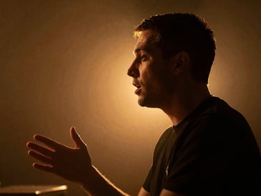 Cinematic side profile of a podcaster speaking with passion, dramatic low-key lighting, warm gold backlight, 35mm grain