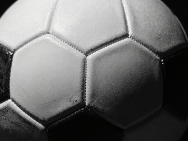 Close-up of a textured professional soccer ball panel seam, sharp focus, dramatic studio lighting, deep shadows, 35mm film