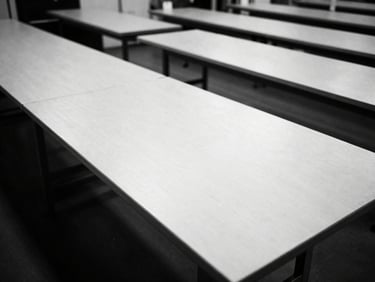 Stark monochrome overhead shot of pristine cutting tables in a modern apparel factory, precise alignment, 35mm film