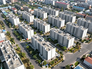Aerial view of planned residential sectors in Gurugram, showing organized street grids, green patches, and mid-rise residential buildings, clear day.