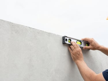 Close-up of a construction professional using a spirit level on a smooth plaster wall, bright natural daylight, clean minimalist aesthetic