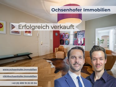 Real estate agents from Ochsenhofer Immobilien in front of a modern living room successfully sold.