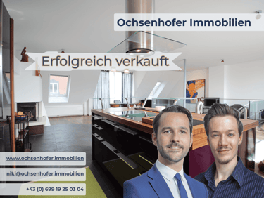 Ochsenhofer Immobilien real estate agents shown in a modern luxury kitchen after a successful sale.
