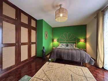 Tropical style bedroom with green walls, rattan headboard, bamboo light, and woven wardrobe doors.