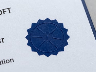 Macro studio shot of a physical skill certificate on heavy textured paper, crisp navy blue security seal in focus, clean neutral lighting