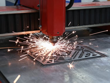 Industrial fiber laser machine cutting a geometric pattern onto a stainless steel sheet, intense white-hot sparks showering down, high-contrast workshop setting