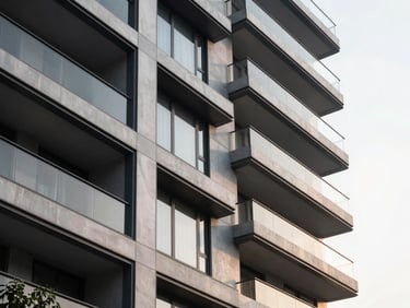 Sleek geometric detail of a modern luxury residential facade in Noida, crisp morning light, architectural minimalism.