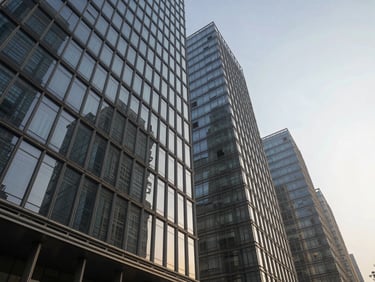Low-angle architectural perspective of Masters Infra Capitol Avenue in Sector 62 Noida, showing sleek glass facades under crisp morning light with dramatic vertical lines.