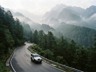 Wide environmental shot of a clean white private SUV driving along a winding mountain road in Himachal Pradesh, surrounded by tall mist-covered pine forests, soft morning daylight, 35mm lens