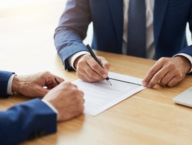 Hands of professionals reviewing a business plan in a bright modern office, warm golden tones