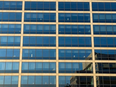 Abstract geometric pattern of modern building glass in N'Djamena, reflecting clear blue sky