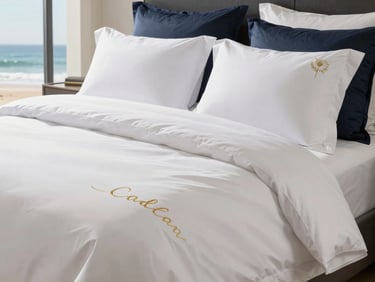 Perfectly folded crisp white luxury linens on a bed in a sunlit bedroom, subtle gold embroidery, luxury architectural photography, bright warm coastal daylight, deep navy and gold accents, high-end editorial, 35mm