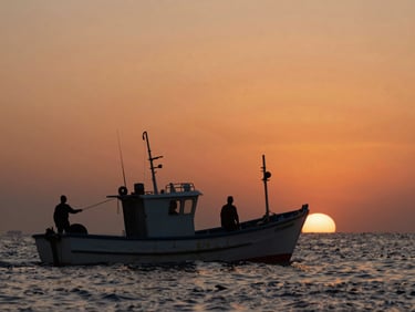 Documentary film still, wide shot of a coastal fishing boat at dusk, crew silhouetted against a deep orange sky, horizon level, salt spray diffusing the far light