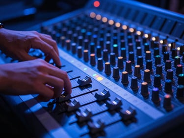 Close-up of a high-end mixing console, with hands adjusting faders, low-light, vibrant blue stage lighting, 35mm lens