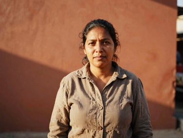 Medium portrait of a female cooperative leader in an outdoor market setting, natural golden daylight, warm terracotta tones
