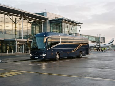 Modern luxury coach parked at a UK airport terminal at golden hour, clean lines, professional aesthetic, soft overcast daylight, deep navy and gold tones, crisp architectural framing, 35mm