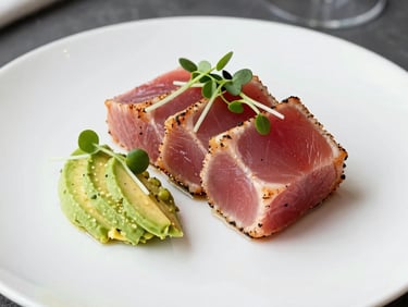 Artfully plated seared ahi tuna with avocado puree and delicate microgreens on a white slate plate, modern corporate fine dining photography, North American / US.