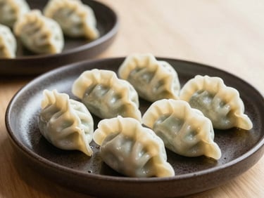 A beautiful gourmet appetizer plate with hand-crafted dumplings on dark ceramic dishware, warm natural daylight studio setting, styled for an upscale North American / US restaurant.
