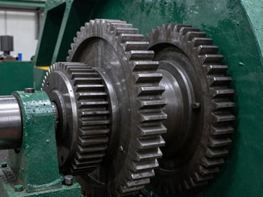 Macro shot of heavy steel cutting gears and drum inside an industrial facility, sharp metal edges, deep green paint, 35mm.