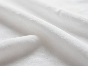 Close-up macro shot of crisp white linen fabric texture with clean folds under bright, natural diffused morning light, shallow depth of field, 35mm