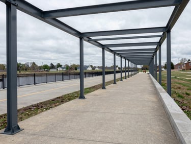 Wide panoramic view of clean public infrastructure in Mckeesport, with honest overcast daylight reflecting off structured steel and concrete pathways.