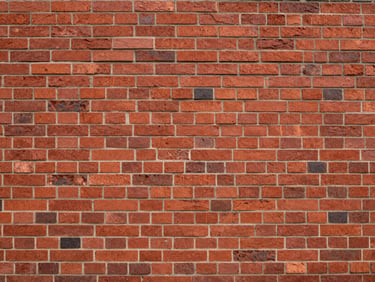Straight-on architectural detail of clean red brick masonry under overcast daylight, emphasizing structural stability.