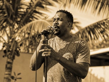 Portrait noir et blanc contrasté d'un chanteur de rumba sous une lumière dorée, style éditorial