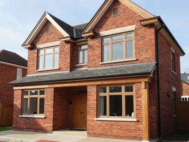 Exterior view of a double-height brick residential extension matching the original Victorian house perfectly, crisp morning light