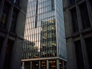 Brutalist concrete and glass corporate headquarters in London, low-key lighting, deep charcoal tones, 35mm film