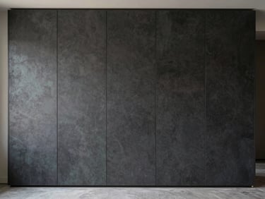 Architectural straight-on shot of a finished wall panel installation, deep textured surface in dark charcoal tone, precise vertical seams, soft directional daylight from the left revealing panel depth, empty room, no people