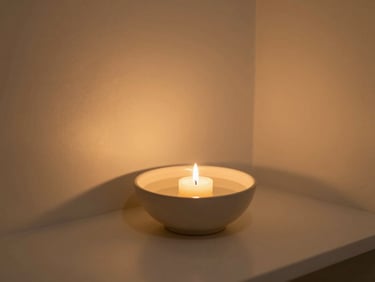 A quiet, minimalist spa corner with a single burning candle casting a warm ambient glow on a ceramic bowl of water, soft shadows, tranquil atmosphere.