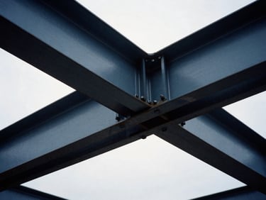 Tight macro shot of heavy steel beams bolted together, industrial yard background, overcast daylight