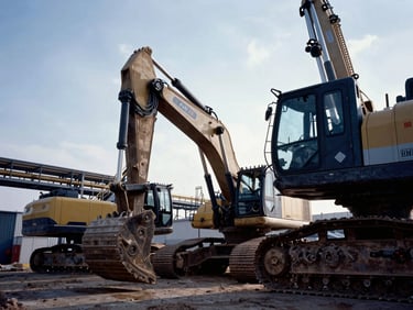 Heavy machinery operating at a massive industrial project site, dramatic side-lighting, cool industrial tones