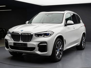 Front three-quarter angle of a white BMW X5 SUV under white showroom strobe lighting, dark background, chrome details sharp, no people