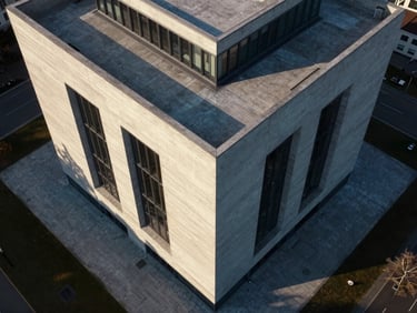 Directly overhead nadir drone shot of a modern architectural building with sharp concrete lines and shadows, crisp morning light