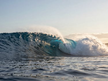 Low-angle shot of a massive hollow wave breaking over a shallow reef, dramatic golden hour dawn light shining through the water, 35mm