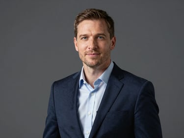 Professional portrait of John Doe, crisp corporate photography, sharp natural daylight, deep navy and slate tones, high contrast, professional editorial style.