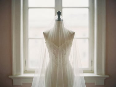 A classic chapel-length bridal veil draped over a mannequin, soft window light, romantic editorial photography