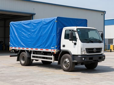 A robust pickup truck with cargo secured under a heavy-duty blue tarp, parked on a clean concrete lot, bright natural daylight, high-contrast industrial tones, sharp focus, 35mm lens