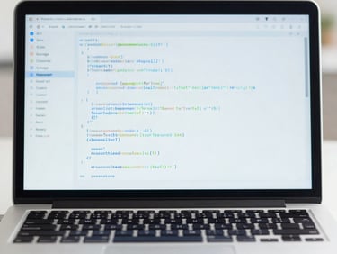 Clean tech photography of a laptop displaying structured code, bright natural daylight, blue and white tones, 50mm lens.