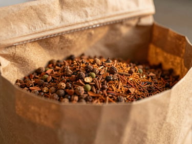 Close-up of a rustic, textured paper bag with a resealable seal, filled with whole spices, warm golden hour light, macro depth of field, rich terracotta tones.
