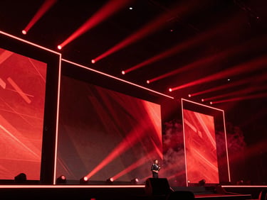 Low-angle shot of a dynamic e-sports tournament stage, massive screens flashing, red spotlight beams cutting through smoke